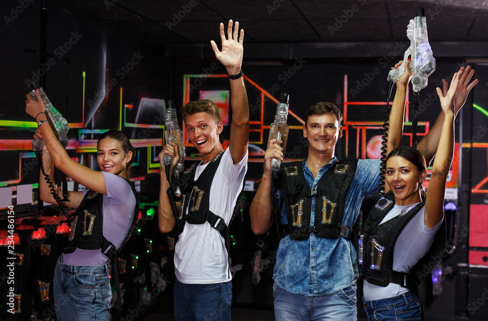 Fototapeta premium people with laser guns having fun together in dark labyrinth