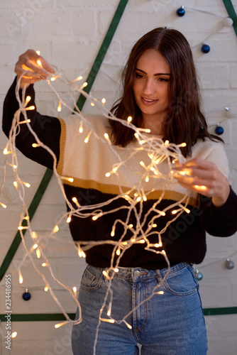 woman untangling fairy lights for her christmas tree photo