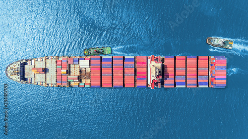 Aerial top view Tug boats drag container ship to sea port for unload container to container warehouse for logistics import export, shipping or transportation concept.