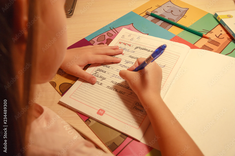 girl holding a pencil and writing in a notebook words and letters girl holding a pencil and writing in a notebook words and letters