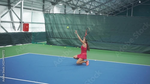 Girl tennis player kicks the ball from her knees