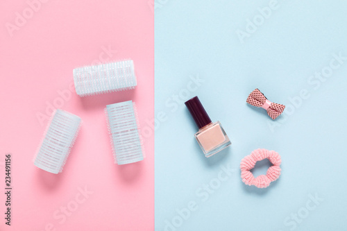 hair curlers on blue and pink paper background
