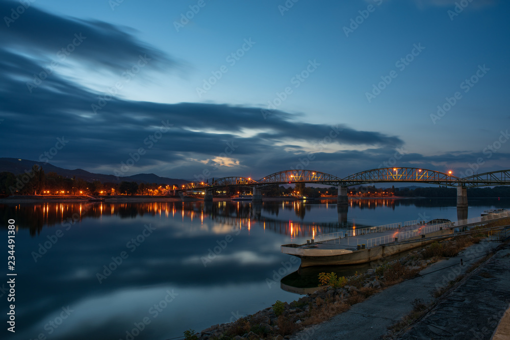 Scenic nightscape of Maria Valeria bridge with reflection in Danube river, Esztergom, Hungary at early morning