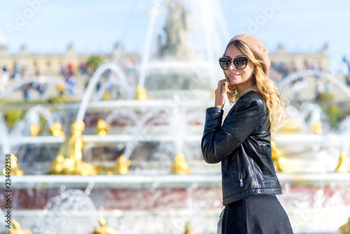 Woman at Versailles Palace. Young french dressed tourist girl admiring the views. Portrait soft bokeh background. Fountaines