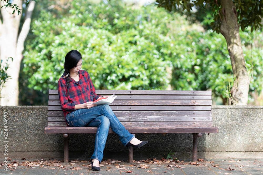 公園のベンチで本を読む女性 公園のベンチで本を読む女性