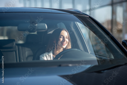 Young businesswoman driving a luxury car, view from the outside through the windshield © rh2010