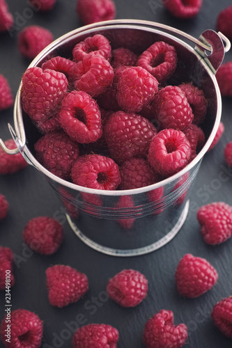 Ripe raspberries in a small bucket