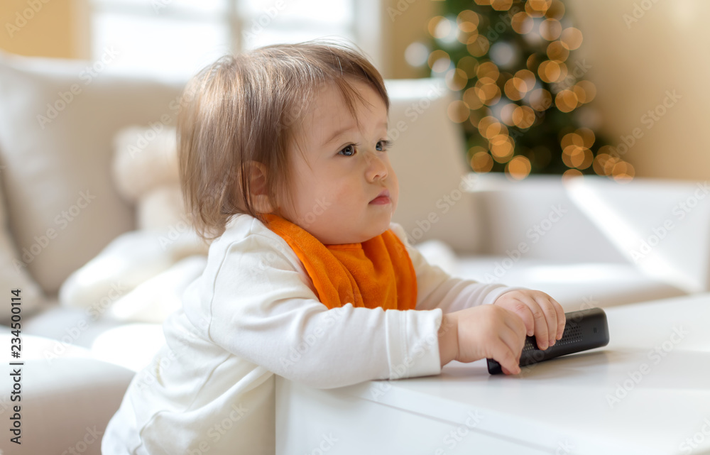 Little toddler boy with a TV remote control Little toddler boy with a TV remote control