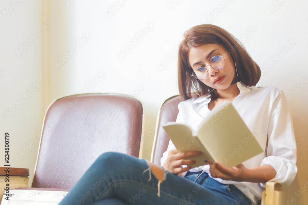Woman in white shirt reading a favorite book in the cafe. Woman in white shirt reading a favorite book in the cafe.