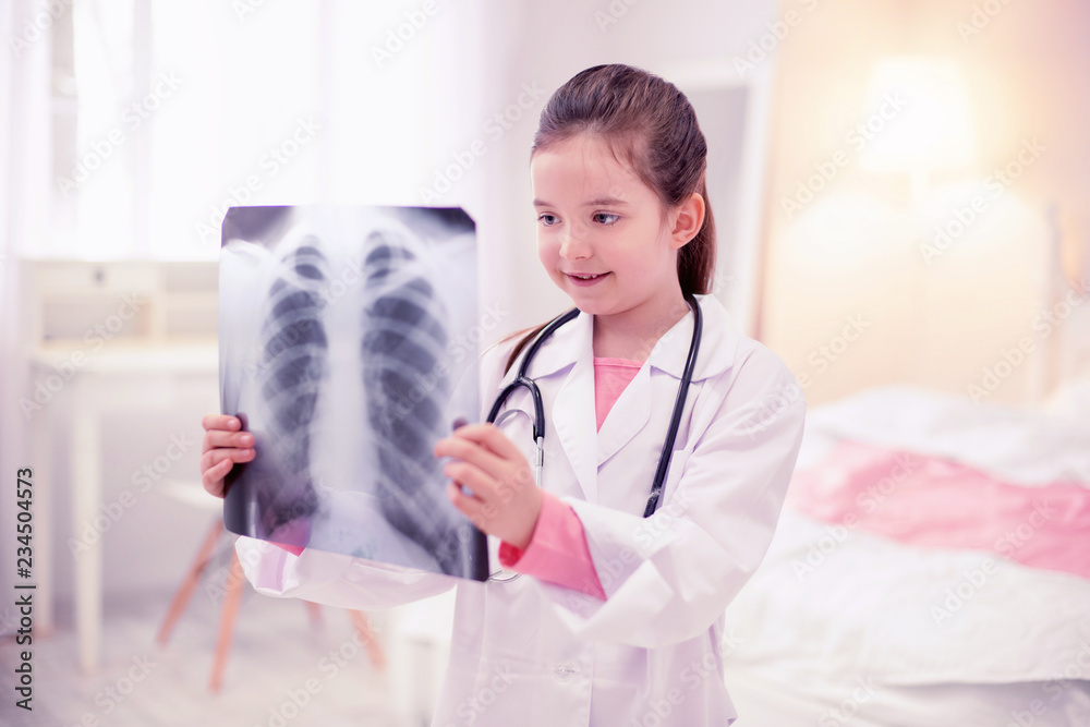 Work of mom. Cute little dark-haired girl coming to the workplace of her mom and looking at x-ray Work of mom. Cute little dark-haired girl coming to the workplace of her mom and looking at x-ray