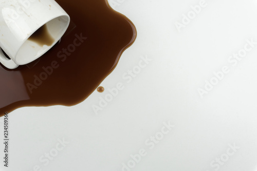 top view of a cup of coffee and spilled coffee on the white table