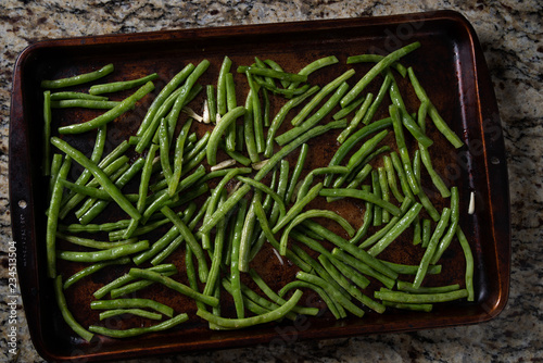 Green beans and garlic on a baking sheet