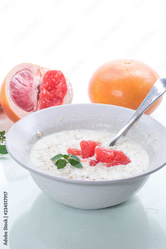 sweet oatmeal with slices of red grapefruit in a ceramic bowl sweet oatmeal with slices of red grapefruit in a ceramic bowl
