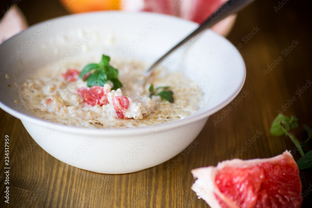 sweet oatmeal with slices of red grapefruit in a ceramic bowl sweet oatmeal with slices of red grapefruit in a ceramic bowl