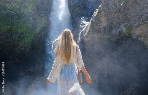 Girl on the background of a waterfall