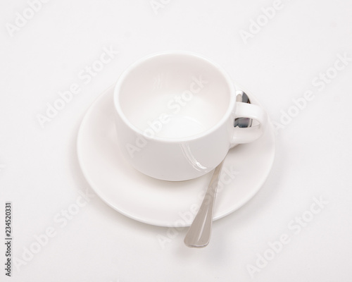 White saucer cup spoon on white background isolation  top view