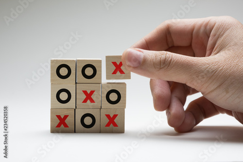 Business or marketing strategy planning concept using wooden cubes tic tac toe board game photo