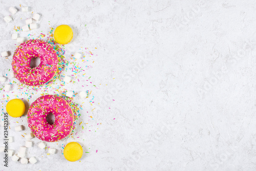 Light background with donuts,  macarons and marshmallow