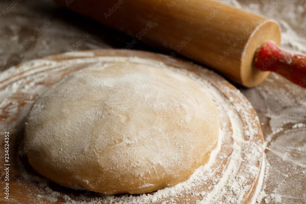 Dough and roller pin on flour covered table in natural light. Dough and roller pin on flour covered table in natural light.