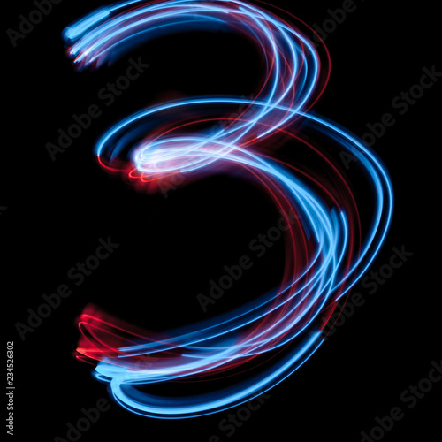 The neon number 3, blue light image, long exposure with colored fairy lights, against a black background