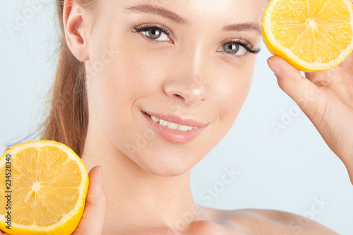 Young beautiful girl with clean perfect skin with lemon close-up
