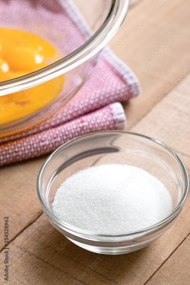 Glass dish of sugar with a bowl of egg yolks, and space for text on top Glass dish of sugar with a bowl of egg yolks, and space for text on top