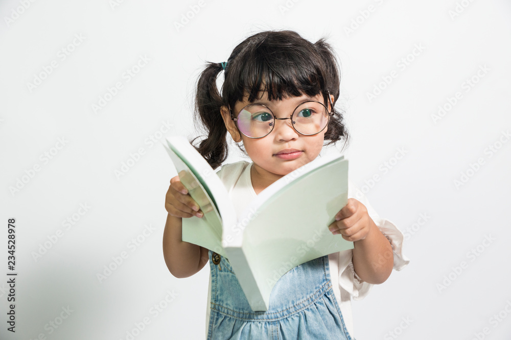 Asian little cute girl reading the book for knowledge . Isolated over white background. clever kid and intelligence concept Asian little cute girl reading the book for knowledge . Isolated over white background. clever kid and intelligence concept