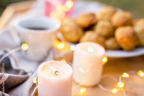 Coffee table served with coffee cup, sweet cookies and candles outdoors