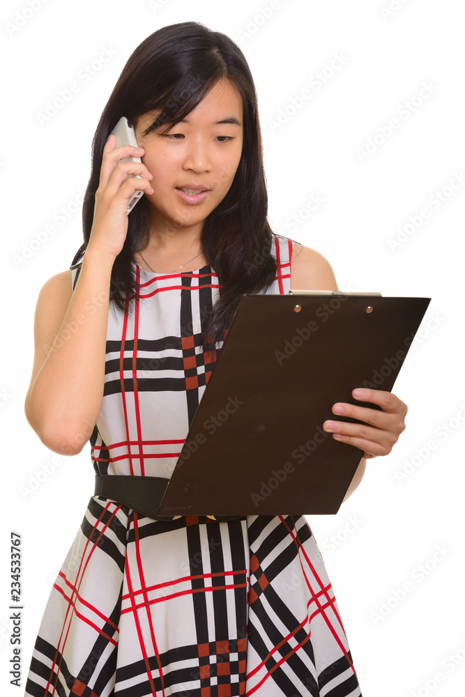 Young beautiful Asian businesswoman reading clipboard while talk Young beautiful Asian businesswoman reading clipboard while talk