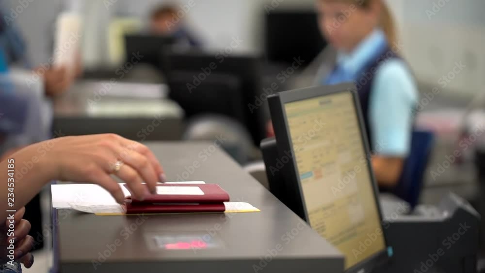 airport employee checking passport of people passengers on border and selling tickets in airport counters. check-in on board aircraft, close up, close-up, Checking passports at the airport check in.