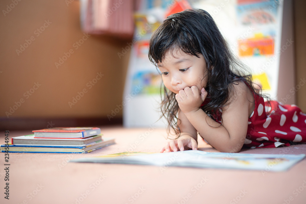 A cute little child Asian girl doing homework and reading a book. Kid enjoy learning with happiness at home. Clever,Education and smart learning concept A cute little child Asian girl doing homework and reading a book. Kid enjoy learning with happiness at home. Clever,Education and smart learning concept