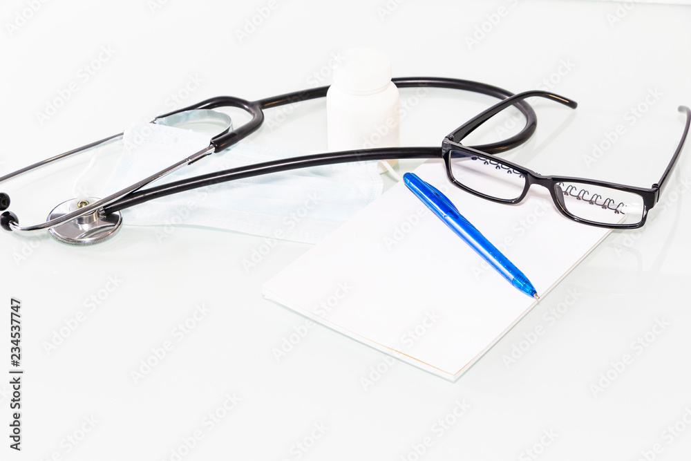 Stethoscope in the office of doctors.Top view of doctor's desk table, blank paper on clipboard with pen. Copy space. Stethoscope in the office of doctors.Top view of doctor's desk table, blank paper on clipboard with pen. Copy space.
