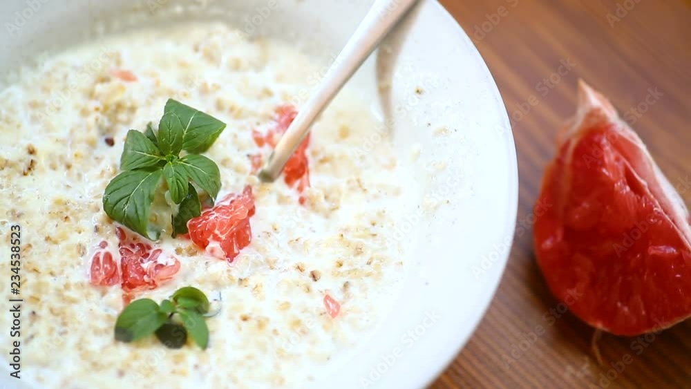 sweet oatmeal with slices of red grapefruit in a ceramic bowl sweet oatmeal with slices of red grapefruit in a ceramic bowl