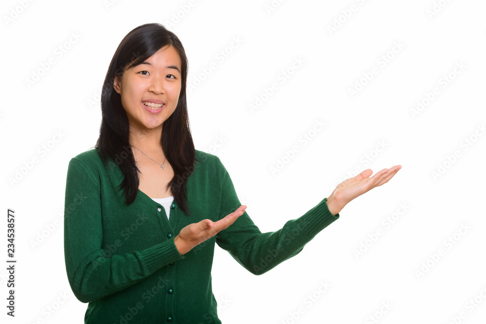 Portrait of young happy Asian woman showing something Portrait of young happy Asian woman showing something