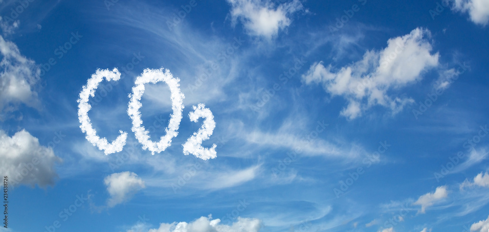 Naklejka premium CO2 inscription painted with clouds on a blue background with white clouds