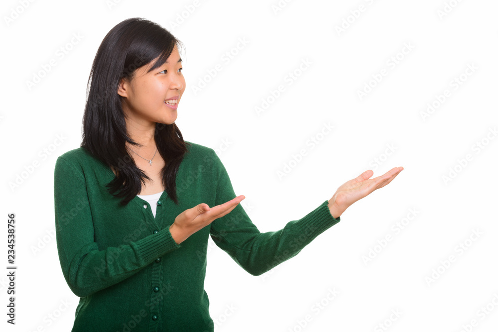 Portrait of young happy Asian woman showing something Portrait of young happy Asian woman showing something