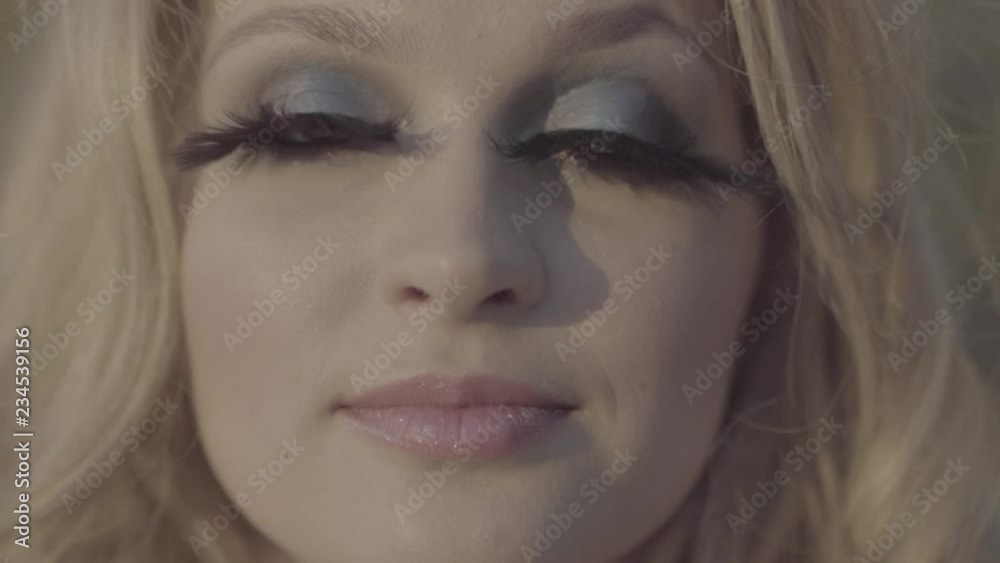 Portrait of woman is looking in camera close up Female has false eyelashes Blonde with green eyes and long eyelashes S-log, ungraded Portrait of woman is looking in camera close up Female has false eyelashes Blonde with green eyes and long eyelashes S-log, ungraded