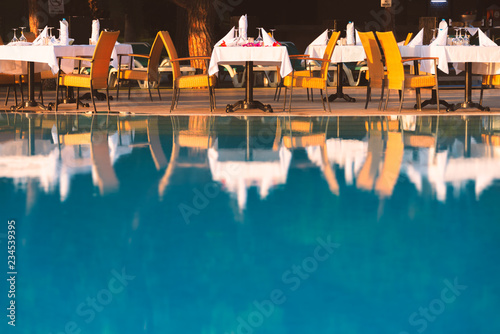 Chairs and table near pool at hotel restaurant photo