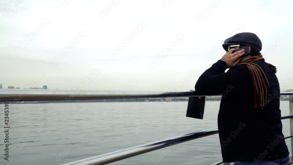 Man talking by smartphone on the boat. Panorama of the city in autumn. 4K Man talking by smartphone on the boat. Panorama of the city in autumn. 4K