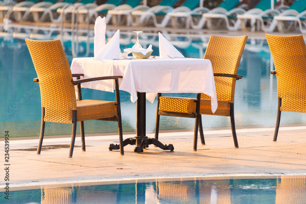 Chairs and table near pool at hotel restaurant