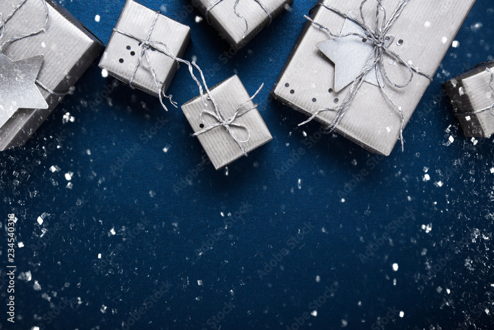 Merry Christmas and Happy Holidays greeting card, frame, banner. New Year. Noel. Silver Christmas gifts, ornaments on blue background top view. Winter holiday xmas theme. Flat lay. Merry Christmas and Happy Holidays greeting card, frame, banner. New Year. Noel. Silver Christmas gifts, ornaments on blue background top view. Winter holiday xmas theme. Flat lay.