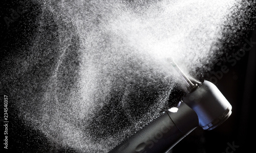 Fotografie, Obraz Dental handpiece with diamond bur and water splash motion on dark background