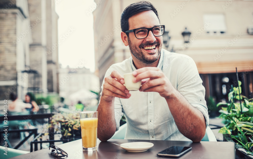 Young man sitting in the cafe and drinking coffee. Lifestyle concept ...