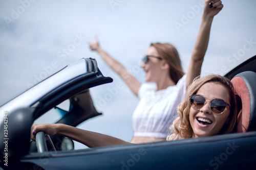 close up.two girlfriends traveling in a convertible car © ASDF