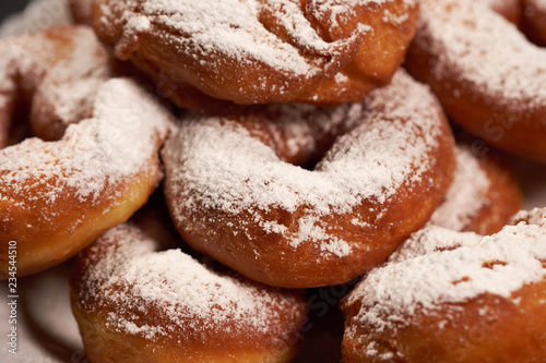 doughnuts sprinkled with powdered sugar on a white plate, selective focus