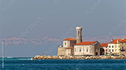 The Lighthouse of Piran (Slovenia) at the adriatic sea with the Alps in the background