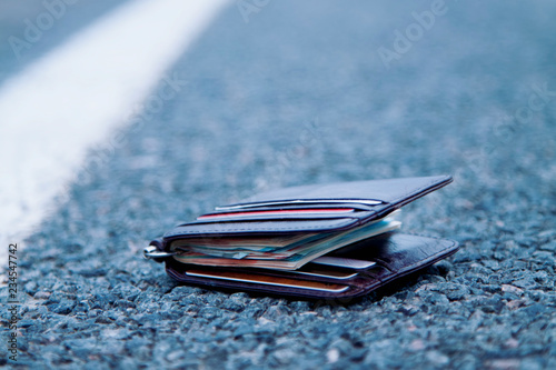 Obraz na plátně Wallet with money on the road. Wasted time is money lost concept.