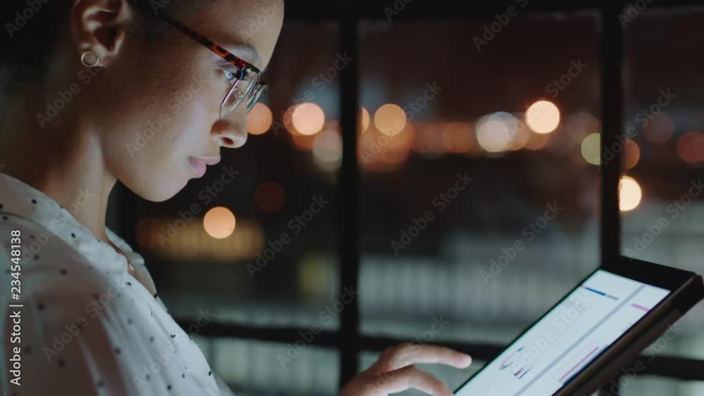 close up beautiful business woman working late using tablet computer browsing research data statistics on screen brainstorming successful project deadline strategy looking out window planning ahead