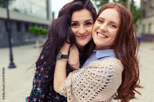 Carefree smiling sisters hugging and having fun together photo