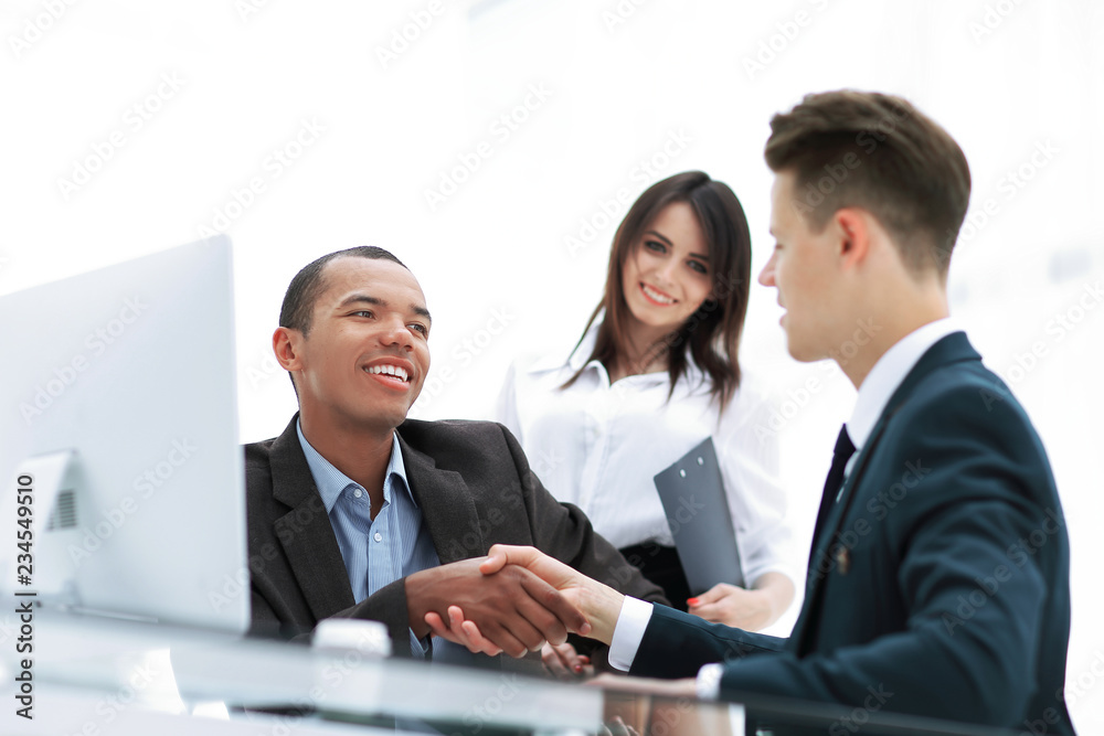 handshake of business partners sitting at a table Desk handshake of business partners sitting at a table Desk